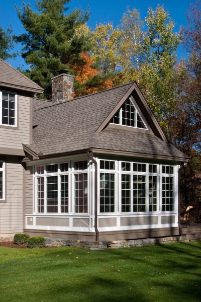 Casement windows with transoms and fixed clerestory windows in the addition gable make for a sunlit enclosed retreat, while the exterior space features a gas fireplace and durable, low-maintenance composite decking.